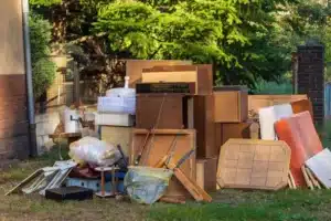 A pile of discarded furniture and household items on a lawn for commercial junk removal services.