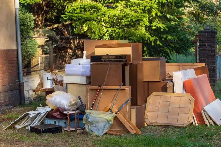 A pile of discarded furniture and household items on a lawn for commercial junk removal services.